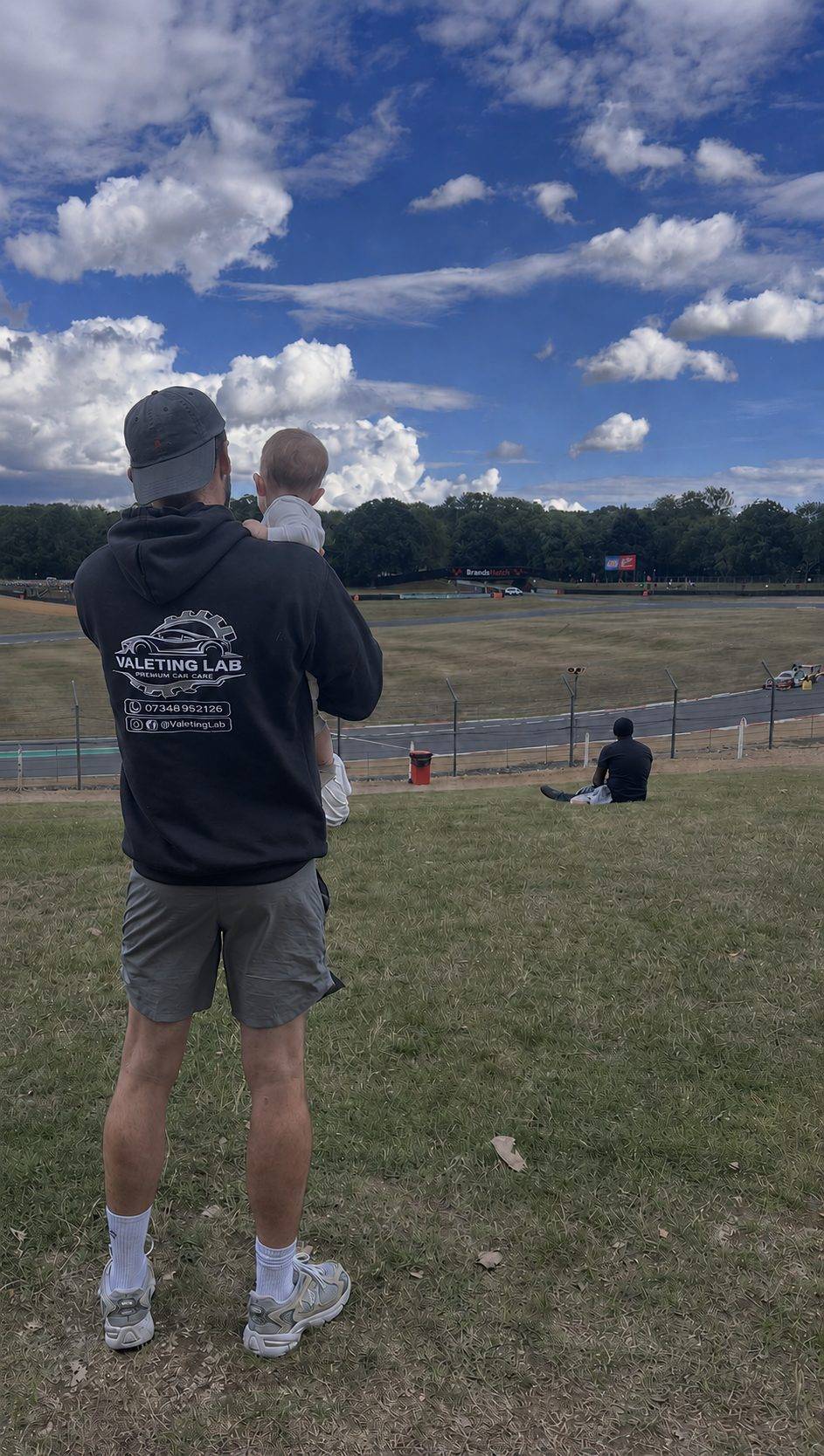 Jem, owner of Valeting Lab, in a branded hoodie at Brands Hatch with his little one