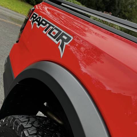 Red Ford Raptor pickup with a deep gloss finish down the rear quarter