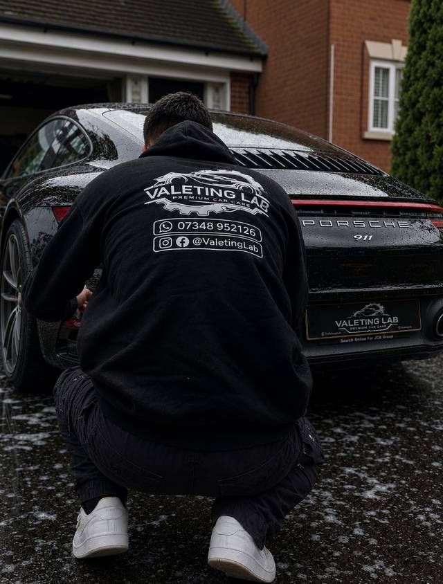 Jem from Valeting Lab detailing the wheels on a black Porsche 911